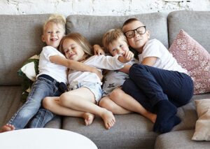 Vier Kinder kuscheln auf der Wohlfühlcouch